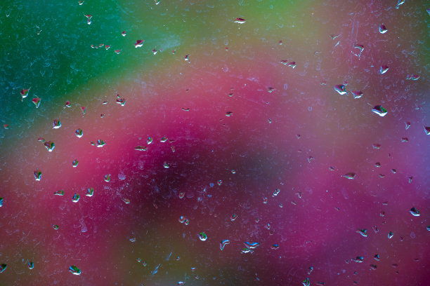 雨点落在彩色背景的窗玻璃上图片下载