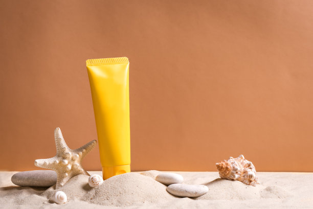 防晒霜，海星和沙滩上的鹅卵石图片下载