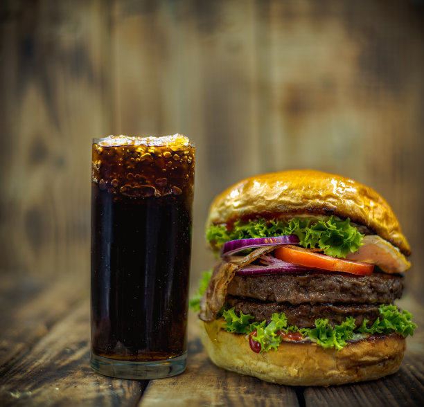 汉堡正面加可乐。木质背景质朴。关闭了。图片下载