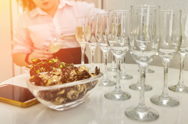 女服务员把起泡白葡萄酒分发给客人。图片下载