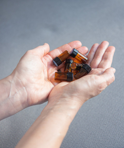 一个女人手里拿着很多玻璃瓶的精油图片下载