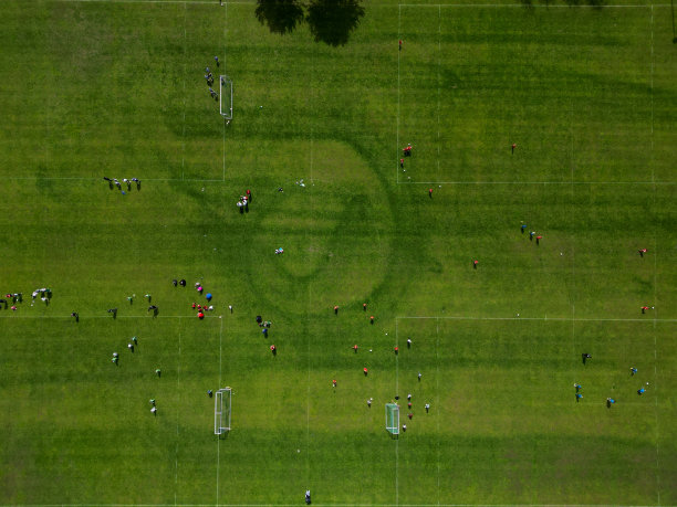 有几个进球的足球比赛体育场。这里的孩子们有一系列的年级淘汰赛。垂直向下观察蜂群。刈条纹草坪图片下载