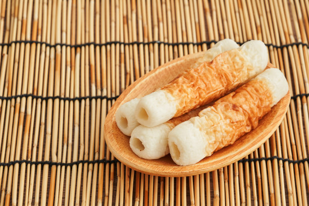 竹纹烤鱼饼，日本料理，以竹为背景，用木盘制作。赤川武部烤鱼饼是日本食品。千家万户烤鱼饼日本料理的背景图片下载