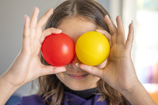 手里拿着红、黄两个球图片下载