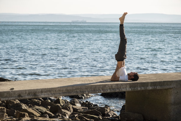 有魅力的年轻人在海边练习瑜伽冥想和呼吸图片下载