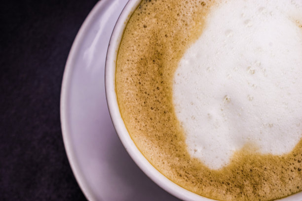 黑木桌上摆着白色杯的热卡布奇诺，俯视图图片下载