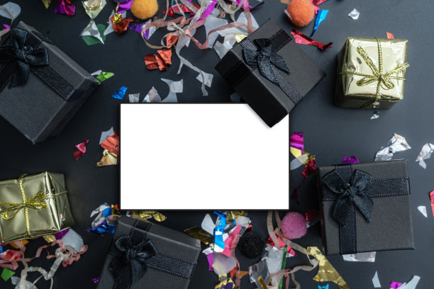 金色缎带闪耀的背景。圣诞节，生日聚会送礼物。黑色和白色的礼品盒与金色缎带闪耀的背景。平的。本空间图片下载