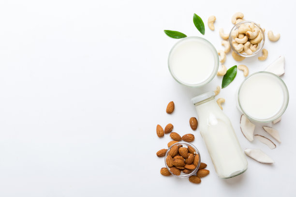集或收集各种纯素牛奶杏仁，椰子，腰果，在桌子的背景。素食植物奶和原料，俯视图图片下载