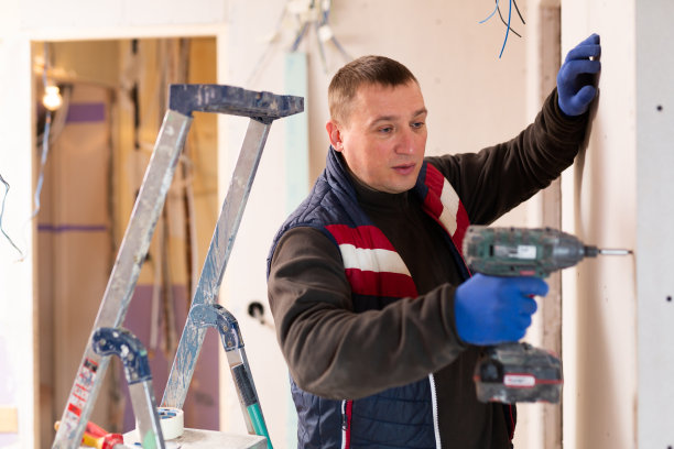 修理工拿着钻头在公寓里工作图片下载