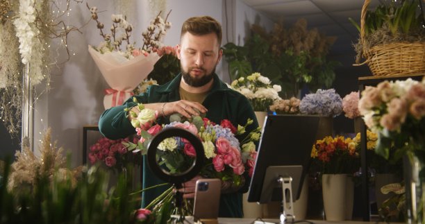 男花商收集花束和记录视频为博客使用手机和平板电脑图片下载