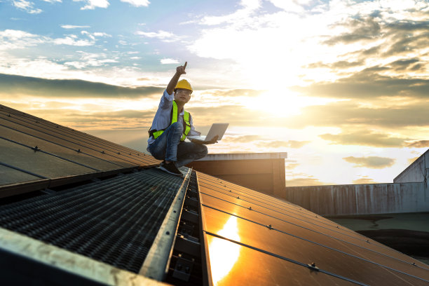 工程师正在屋顶安装太阳能电池板。工程师或工人在商业建筑的屋顶上安装太阳能电池板或太阳能电池图片下载