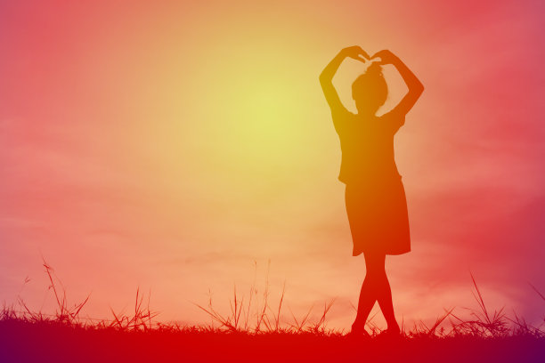 剪影女孩在夕阳下对着天空摆姿势图片下载