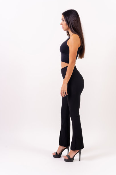 在白色背景上拍摄照片的黑发女子。身穿黑衣，侧身栖息图片下载