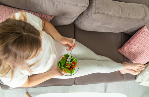 一位孕妇吃蔬菜沙拉。有选择性的重点。图片下载