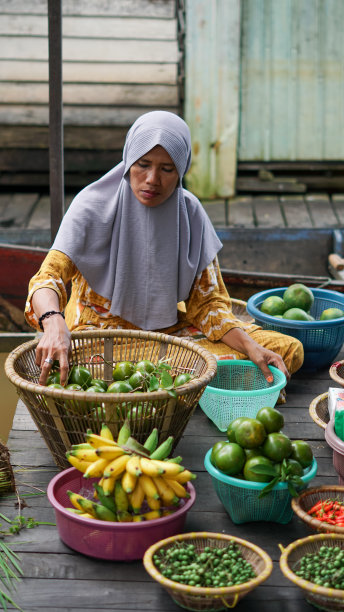 在河边的房子里，班贾尔妇女正在把水果装进篮子里图片下载