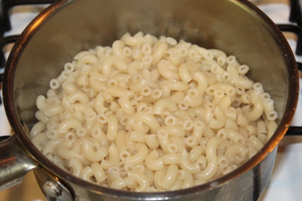免版税照片-网站，美食博客或广告的最佳食物背景-煮熟的肘部通心粉的孤立特写，准备好你选择的酱汁-一些煮熟的意大利面在酱锅里等待奶酪酱-他们称之为通心粉图片下载