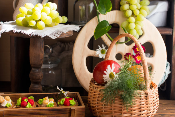 蛋糕和水果放在木制背景上的柳条篮子里。复古风格商店的概念图片下载