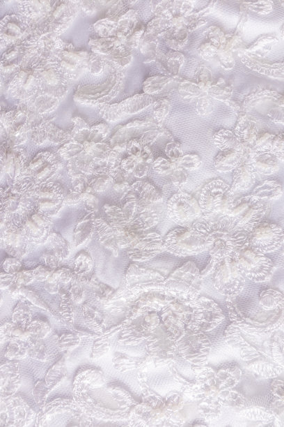 垂直外观别致的刺绣白色缎面织物。绣着珠子和亮片的花。婚礼喜庆背景。图片下载