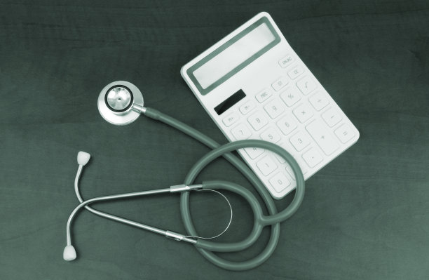 听诊器和计算器放在木桌上图片下载