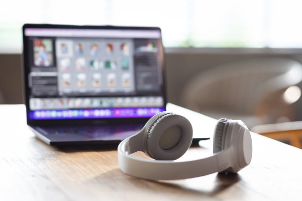 木制背景上的白色耳机和笔记本电脑图片下载