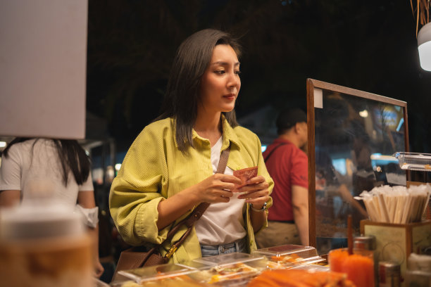 亚洲女人喜欢在夜市吃面条。游客亚洲博主女性快乐的游客美丽的女性与传统泰国曼谷美食。图片下载