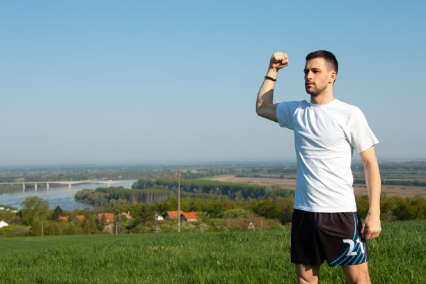 一个男人站起来，双手紧握二头肌，自由，身心健康图片下载