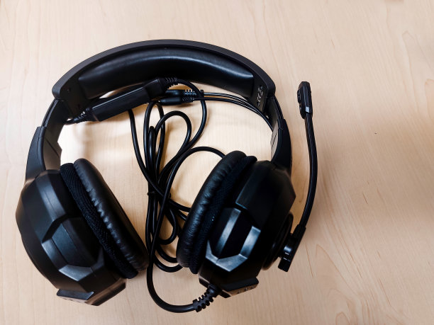 木制背景上的黑色耳机。图片下载