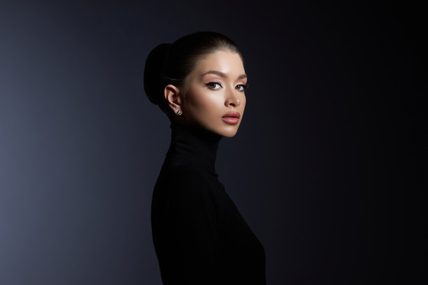 时尚艺术工作室的肖像美丽优雅的女人在黑色高领毛衣。头发高高的横梁，完美的轮廓脸。优雅的美丽风格。耳坠图片下载