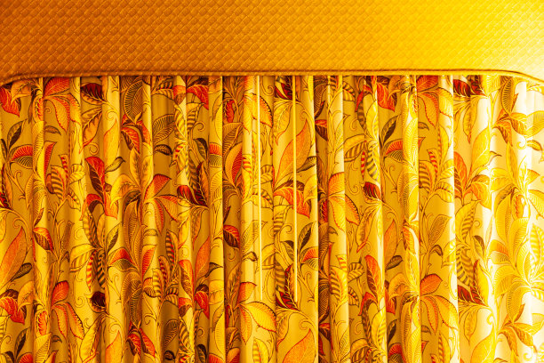 有花卉图案的窗帘挂在房间里，光线柔和，特写。图片下载