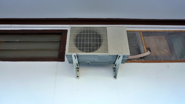 室外空调压缩机悬挂在建筑物靠近窗户和天花板的室外墙壁上图片下载