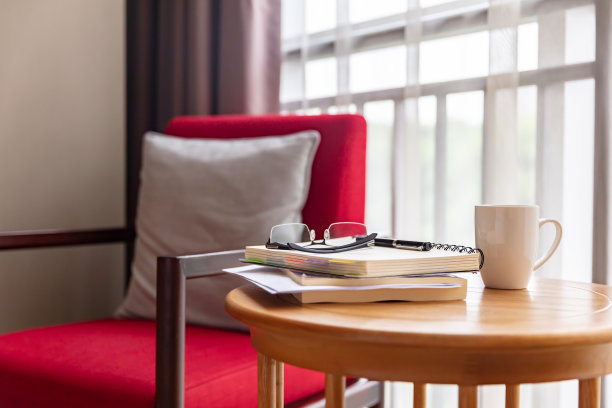 房间里有红色沙发，圆桌上有眼镜、书和咖啡图片下载