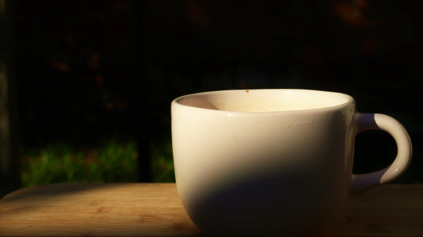 一个大茶杯，侧面。一个巨大的茶杯在户外的桌子上。在阳光下喝一大杯茶。泡茶。后院的热茶杯图片下载