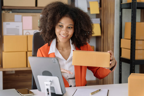 非裔美国女性在家在线直播销售盒子产品。图片下载