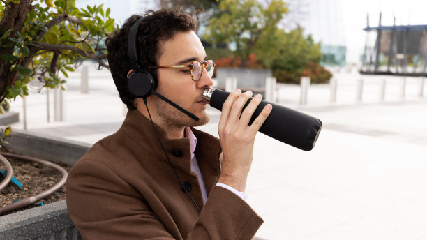 一名男子一边在街上远程办公一边喝水图片下载