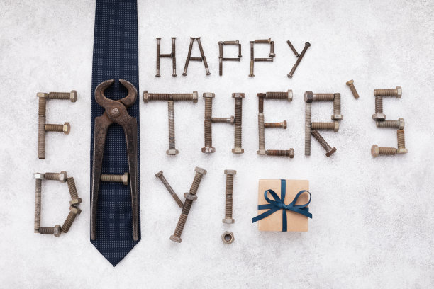 快乐的父亲节贺卡与工具和文字文字从复古螺丝，礼盒和蓝色领带顶视图在白色的石头背景。图片下载