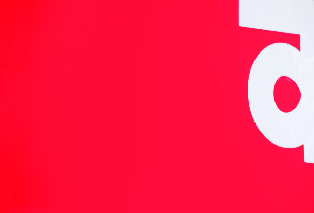 街角亮红色的囤积物的一部分特写，白色的字母形成了一个彩色的抽象。图片下载