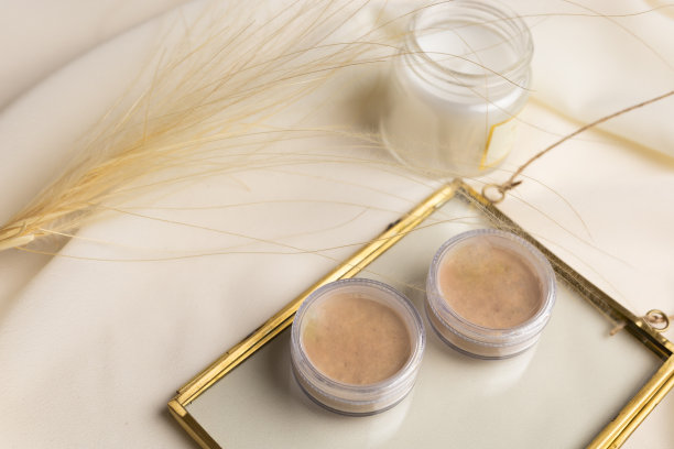 化妆用的粉饼装在盒子里，背景是自然的干花。美颜化妆师美容美学俯视图图片下载