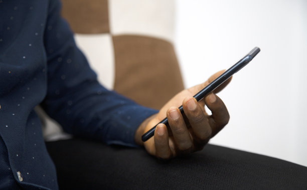 黑手在客厅拿着手机，社交媒体，新闻，娱乐图片下载