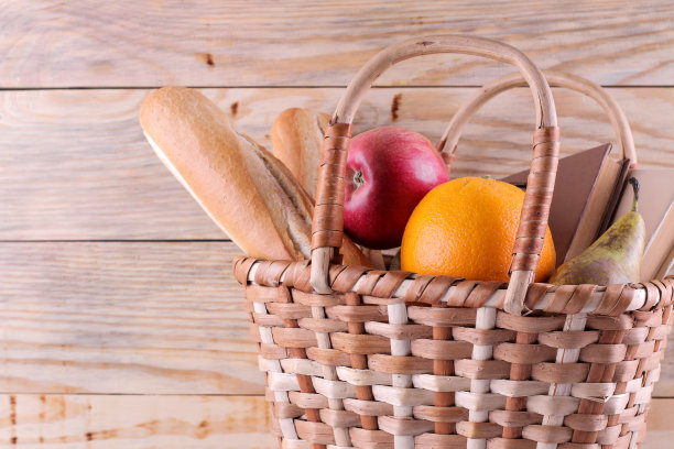 野餐篮与葡萄酒，水果和其他产品在一个天然的木制背景。夏天休息。露营。在大自然中野餐。图片下载