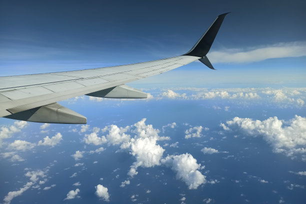 透过飞机窗户看到的商业喷气式飞机机翼在天空中飞行。航空旅行概念图片下载