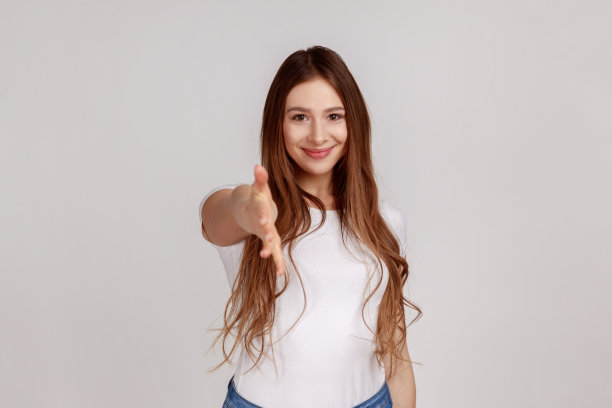 肖像友好的妇女给予握手，欢迎客人的牙齿微笑。图片下载