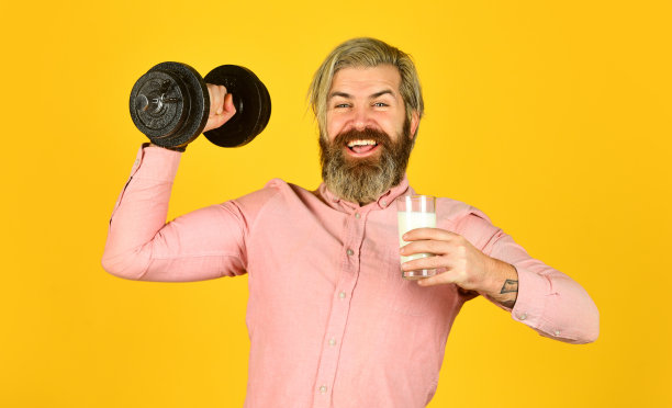 牛奶和减肥。美的概念和健康的好处。快乐的运动员举杠铃。大胡子男人喝有用的牛奶。健身后的健康饮食图片下载