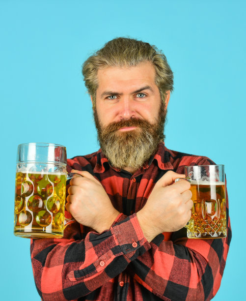 专业的招待。一大杯酒精饮料。自信的调酒师。酒吧里的酒保。在酒吧休息。欢呼。体育酒吧。尝试新啤酒。野蛮的嬉皮士喝啤酒。成熟的大胡子拿着啤酒杯图片下载