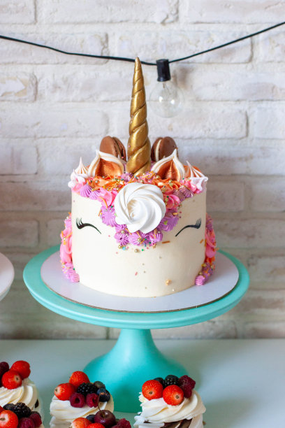 独角兽蛋糕，金色的角，白底奶油，马卡龙和蛋白酥图片下载