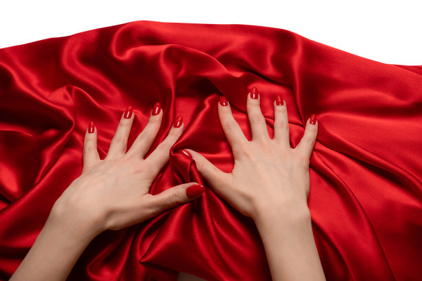 一个涂着红指甲的女人正试图扯掉一块红色的丝织品。图片下载