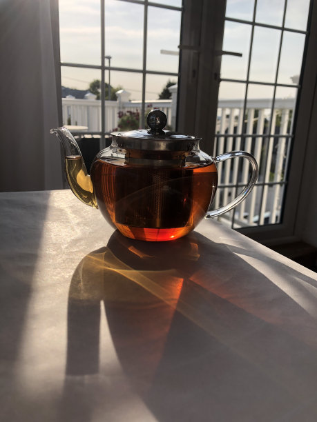 玻璃茶壶和阳光照在靠窗的桌子上。图片下载