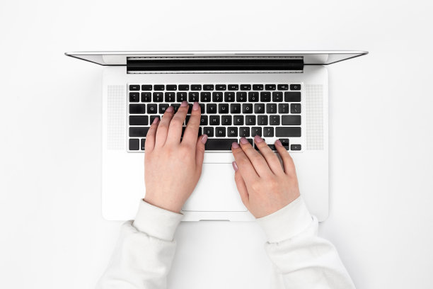 白色背景的笔记本电脑和女性的手，俯视图。图片下载