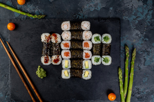 深色背景的亚洲美食、卷饼和寿司图片下载