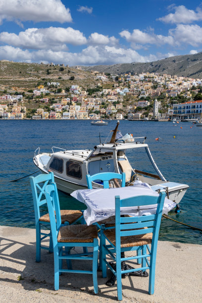 希腊西米岛海滩上的木制桌椅。图片下载