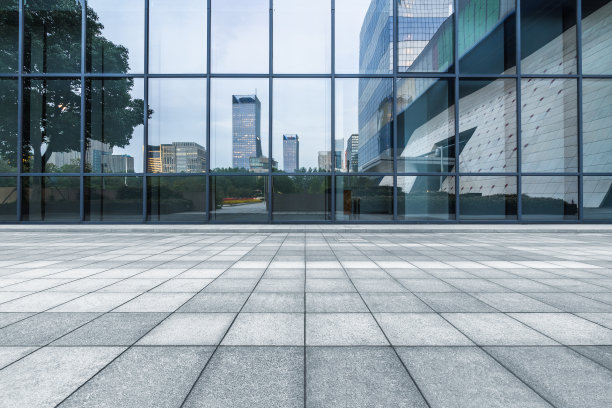 建筑物和干净的道路倒映在玻璃墙上图片下载